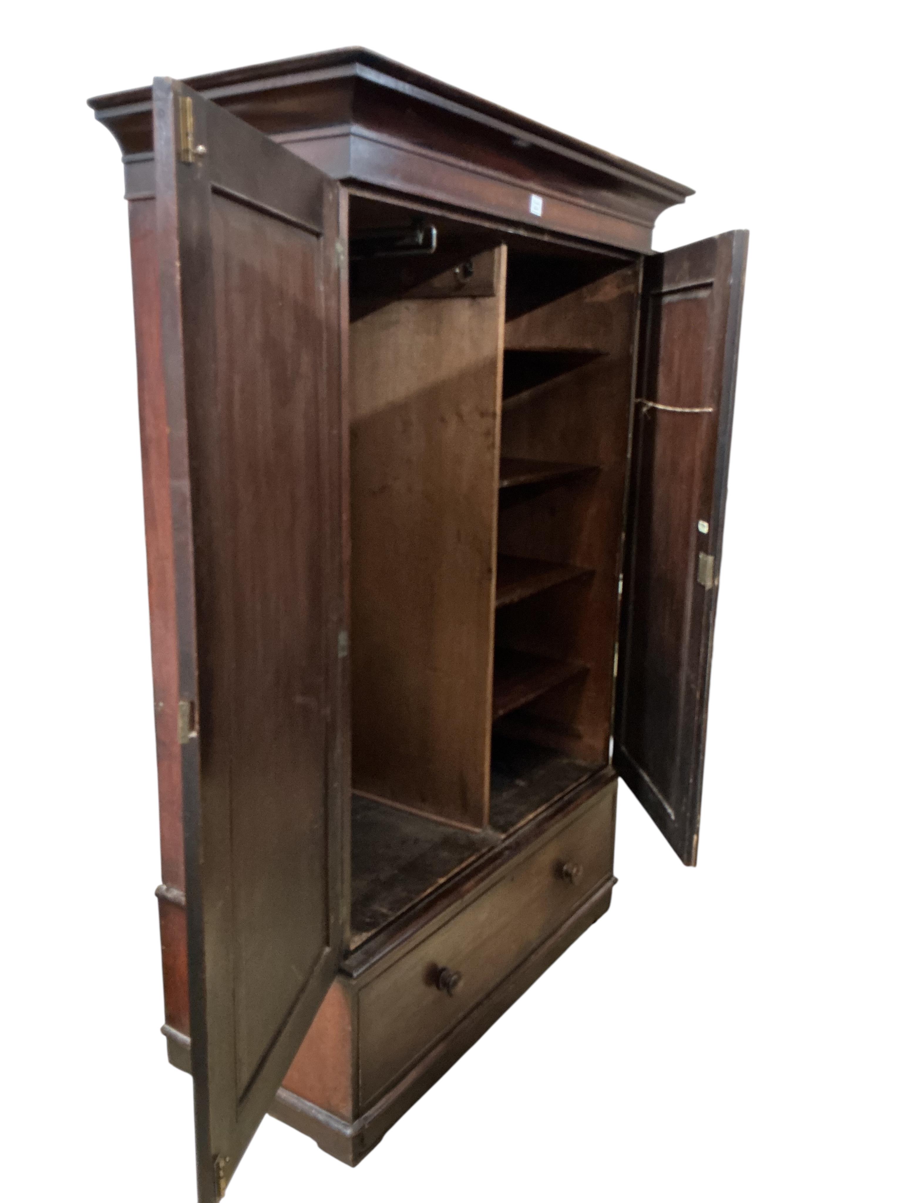 A Victorian mahogany two door wardrobe, fitted with a base drawer, width 140cm, depth 63cm, height 206cm